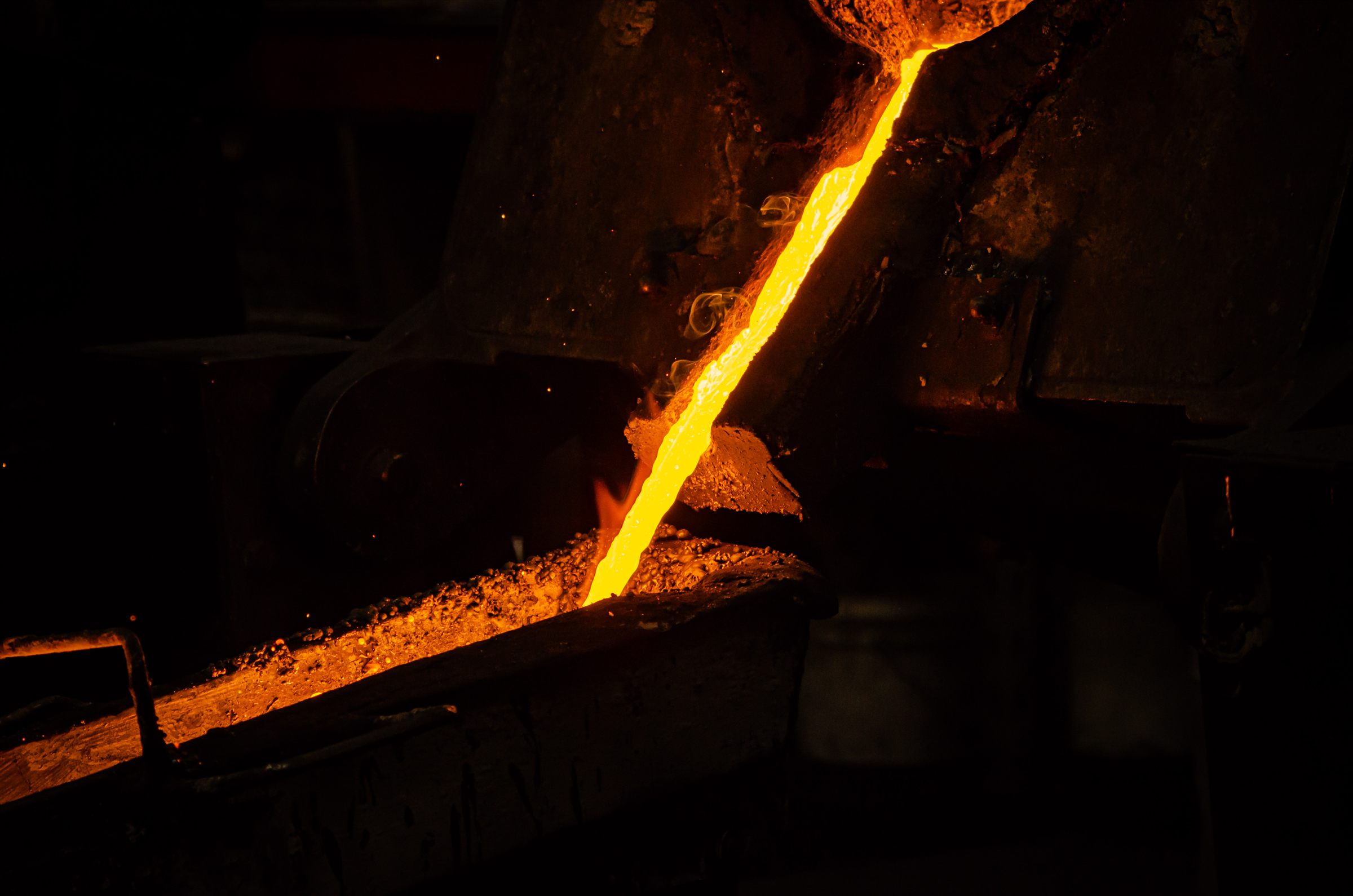 Molten metal pouring from a furnace into a transfer channel