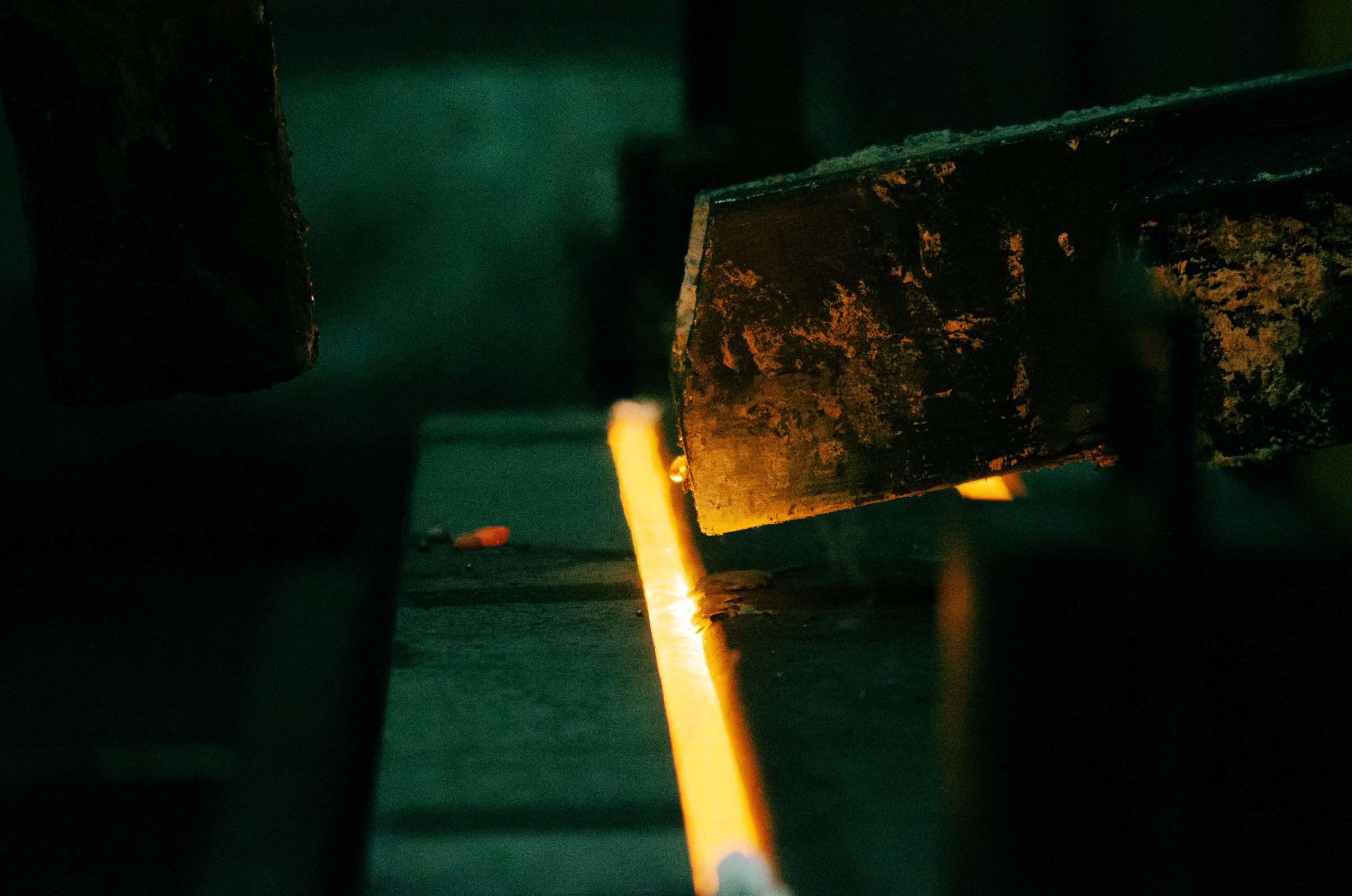 Collector assembly above a glowing metal channel in the smelting process