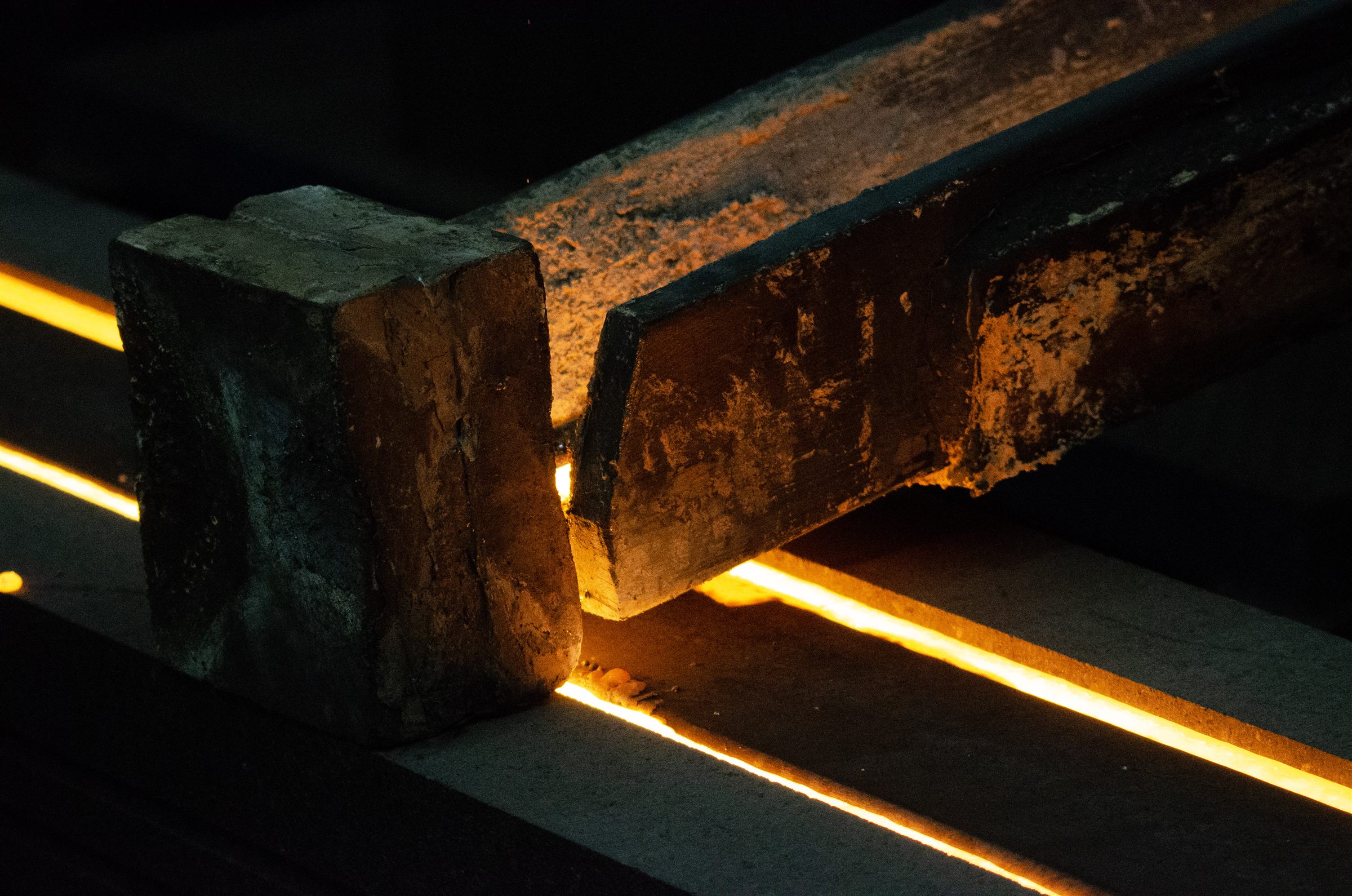 Heavy transfer equipment positioned above glowing molten material