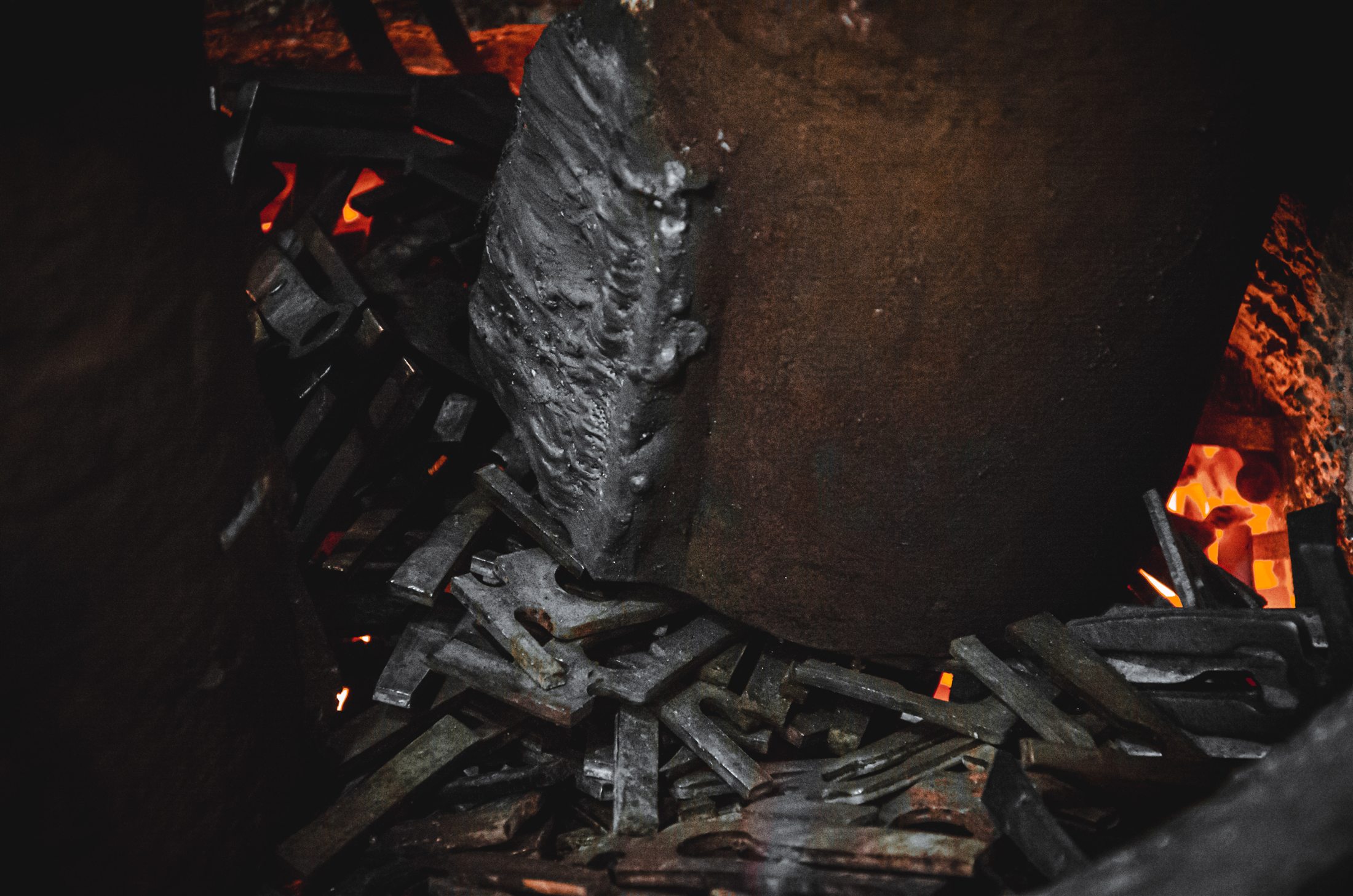 Smelting components surrounded by the glow of an industrial furnace