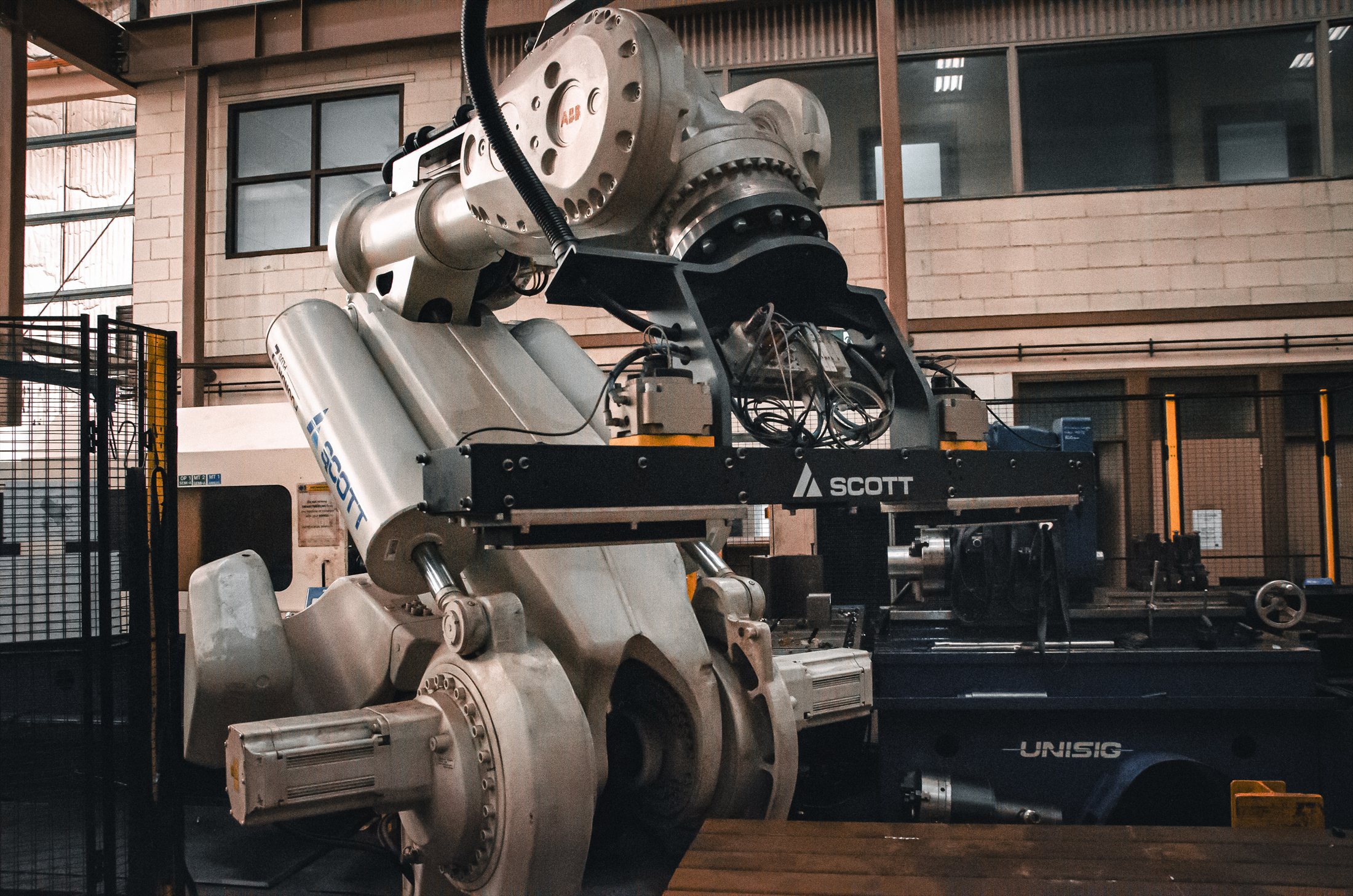 Large industrial robot positioned beside specialist workshop machinery